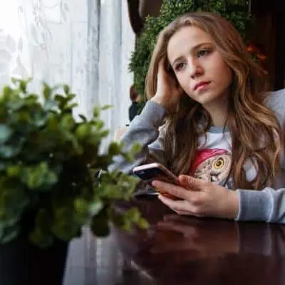 femme triste avec son téléphone