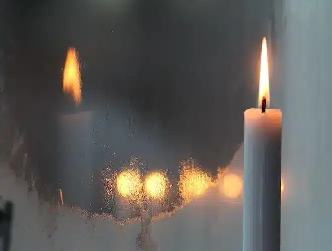 bougie qui brûle et son reflet dans un miroir représentant une flamme jumelle