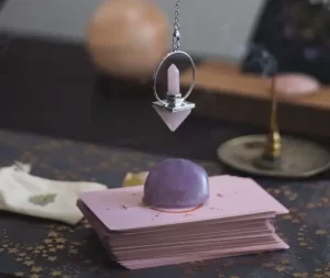 pendule oui non divinatoire en cristal utilisé au-dessus de cartes