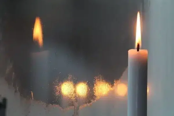 bougie qui brûle et son reflet dans un miroir représentant une flamme jumelle