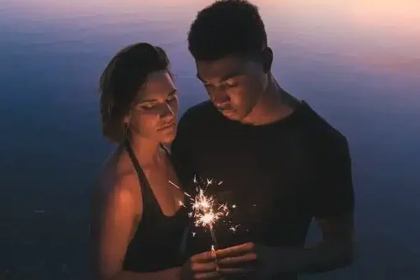 un couple d'âmes sœur tient une bougie qui lance des étincelles