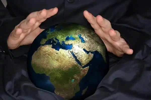 deux mains autour d'un globe terrestre